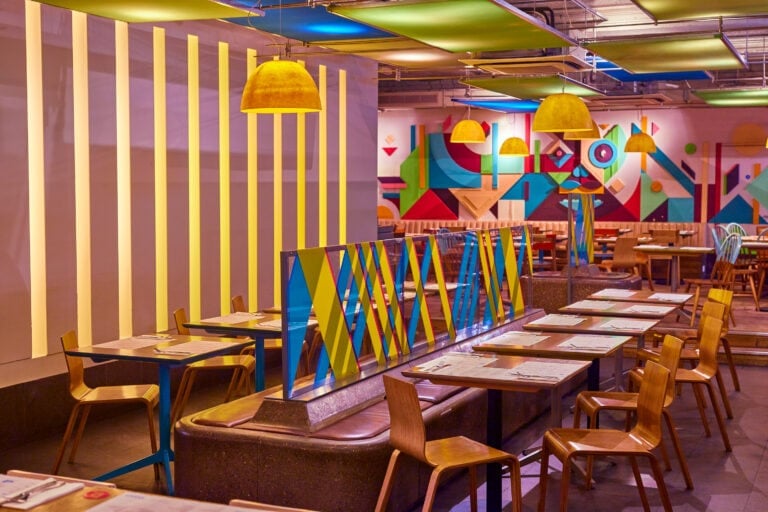 Seating at Wahaca Covent garden with colourful abstract wall art